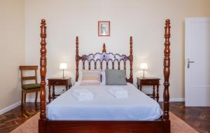 a bedroom with a large wooden bed with two tables at Casa da Nau in Ponta Delgada