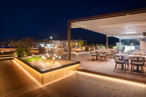 eine Terrasse mit Tischen und Stühlen auf einer Terrasse in der Nacht in der Unterkunft Sallés Hotel Pere IV in Barcelona