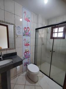 a bathroom with a shower and a toilet and a sink at Pousada Magia do Sol in Florianópolis