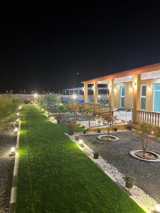 un jardín por la noche con un edificio con luces en مزرعة واستراحة الجوري en Al Khatim