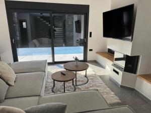 a living room with a couch and a tv at Windmills & The Villas-Aiolos ll in Amarynthos