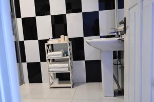 a bathroom with a sink and black and white checkered wall at BeachMirissa Hotel in Mirissa