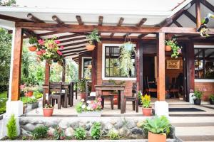a patio with tables and potted plants at Cabaña Don Pacho in Otavalo