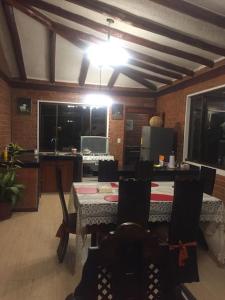 奧塔瓦洛的住宿－Cabaña Don Pacho，用餐室配有桌椅和灯具