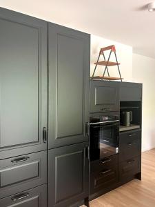 a kitchen with black cabinets and a stove at Wohnung am Wald in Geisa