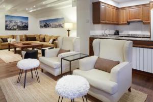 uma sala de estar com cadeiras brancas e uma cozinha em Val de Ruda Luxe 5 by FeelFree Rentals em Baqueira-Beret