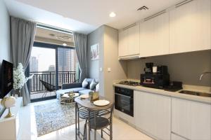 a kitchen and living room with a couch and a table at Canalfront Gem: 1BR in Zada Tower by Livbnb in Dubai