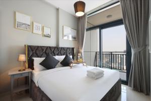 a bedroom with a large bed with a large window at Canalfront Gem: 1BR in Zada Tower by Livbnb in Dubai