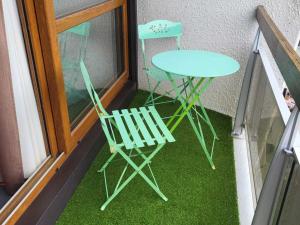 a table and two chairs on a balcony with grass at Studio Villard-de-Lans, 1 pièce, 4 personnes - FR-1-689-90 in Villard-de-Lans