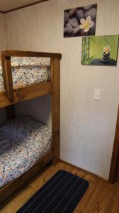 a room with two bunk beds and a rug at Cabaña Los Mañios in Puerto Montt