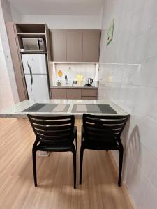 cocina con mesa y 2 sillas negras en LOCALIZAÇÃO PERFEITA! Ap Beira Mar, en Balneário Camboriú
