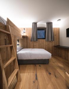 Postel nebo postele na pokoji v ubytování DOLOMITI EXCLUSIVE YOUR MOUNTAIN SUITE