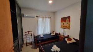Kleines Zimmer mit 2 Betten und einem TV in der Unterkunft Deptos Bajo la Viña in San Salvador de Jujuy
