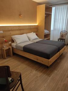 ein Schlafzimmer mit einem großen Bett in einem Zimmer in der Unterkunft L'antica corte apt Mara in Levico Terme