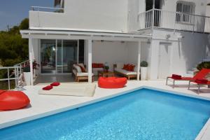 una piscina con almohadas rojas y una casa en Villa Sitges Altavista Amazing View South oriented Calm Area AC Beach 2 minutes, en Sitges