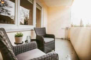 porche con 2 sillas, mesa y ventana en Staylight Cozy Appartement, ruhig und citynah gelegen, Netflix, Premium Ausstattung, en Celle