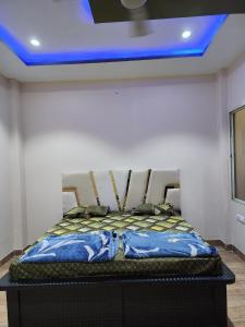a bed in a room with a blue ceiling at Holiday Home in Ujjain