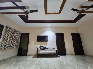 a living room with a couch and a flat screen tv at Holiday Home in Ujjain