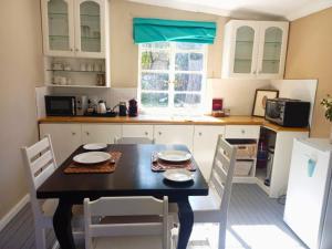 a kitchen with a table and chairs in a kitchen at The Browns' - Cottage Suites in Dullstroom