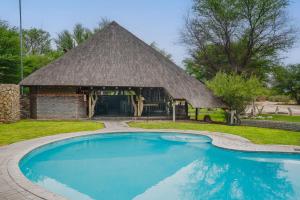 un padiglione con piscina di fronte a un edificio di Grassland Safari Lodge a Ghanzi