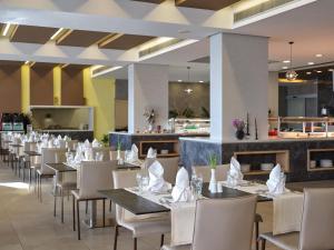 a dining room with tables and chairs and a restaurant at Atlantica Mikri Poli Crete in Makry Gialos