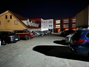 un aparcamiento con coches estacionados frente a los edificios en Hostal Esesur, en Puerto Montt
