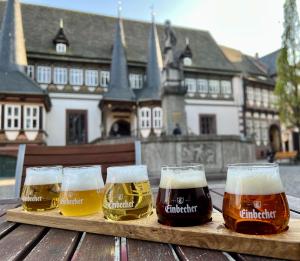 4 Gläser Bier auf einem Holztisch in der Unterkunft Malerhaus Einbeck in Einbeck
