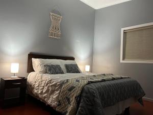 um quarto com uma cama com duas almofadas e uma janela em Hostal Esesur em Puerto Montt