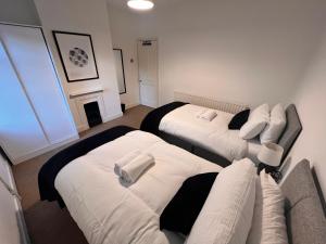 a room with two beds and a fireplace at Visit Luton With This 2 BR Rental - Sleeps 6 in Luton