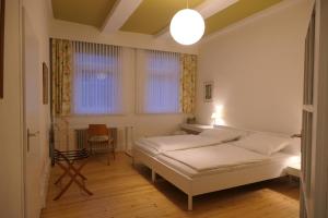 ein Schlafzimmer mit einem Bett und einem Stuhl darin in der Unterkunft Malerhaus Einbeck in Einbeck
