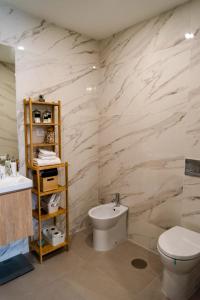 y baño con aseo blanco y lavamanos. en Modern apartment with balcony and free parking en Oporto