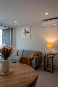 a living room with a blue couch and a table at Modern apartment with balcony and free parking in Porto