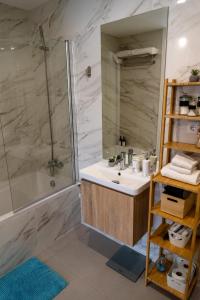 y baño con lavabo y ducha. en Modern apartment with balcony and free parking en Oporto