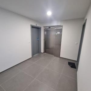 an empty room with two doors and a tile floor at Modern apartment with balcony and free parking in Porto
