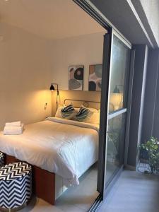 a bedroom with a bed and a large window at Estúdio VN Consolação in Sao Paulo +18 photos