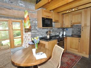 a kitchen with a wooden table with chairs and a kitchen with at 1 Bed in Loch Ness I662C in Invermoriston