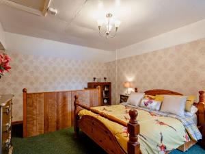a bedroom with a wooden bed and a chandelier at 2 bed in Stanhoe POCN8 in Stanhoe