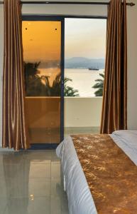 een slaapkamer met een groot raam met uitzicht op de oceaan bij PALM BEACH HOTEL free ticket for pedal boat تذكرة مجانية للالعاب البحرية in Aqaba