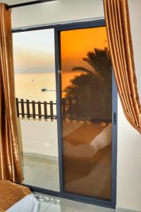 a view of the ocean from a room with a window at PALM BEACH HOTEL free ticket for pedal boat تذكرة مجانية للالعاب البحرية in Aqaba