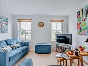 3 Bed in Appledore 28479 في آبيلدوور: غرفة معيشة مع أريكة زرقاء وتلفزيون