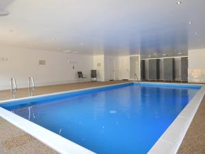 uma grande piscina com água azul num edifício em 4 Bed in Taunton KIBTR em Trull