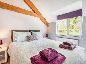 sypialnia z dużym łóżkiem z fioletowymi ręcznikami w obiekcie 3 bed property in Bude 29125 w mieście Thornbury