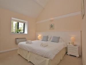 a bedroom with a large white bed with two towels on it at 2 bed property in Shaftesbury 28678 in Sedghill
