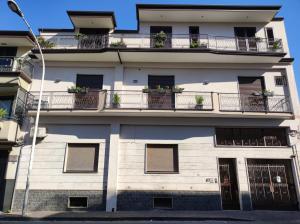 un edificio bianco con balconi e piante di Villa Mafalda B&B a Frattamaggiore