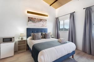 a bedroom with a blue and white bed and a window at Casa Lomo el Aire Brezo in Tegueste +18 photos