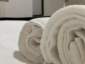 uma pilha de toalhas brancas numa cama em Visit Luton With This 2 BR Rental - Sleeps 6 em Luton