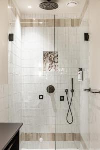 une douche avec une porte en verre dans une salle de bain dans l'établissement Revier, à Oslo 56 autres photos