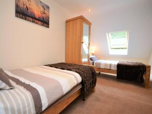 a bedroom with two beds and a mirror at 3 bed in Narberth 36799 