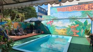 una piscina en un complejo con una pintura en la pared en Oceanic Hostel, en Balneário Camboriú