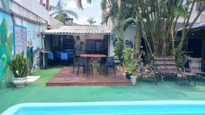 un patio con mesa y sillas junto a una piscina en Oceanic Hostel, en Balneário Camboriú